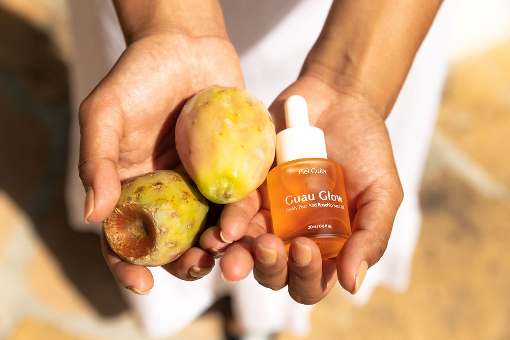 A bottle Guau Glow! by Piel Culta and two prickly pears on a woman's hand.